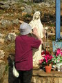 Praying to Our Lady statue at the Blue Cross