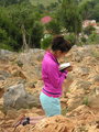 Young woman reading religious book at the Apparition Hill Podbrdo